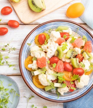 Cauliflower Salad With Cabbage, Kiwi, Tomatoes, And Sprouts